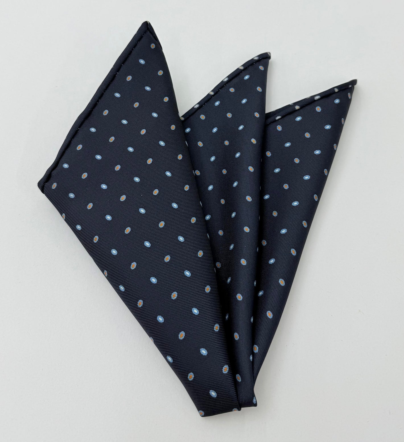 ダークネイビーブルーのマクルズフィールドプリントシルクポケットチーフ（スカイブルー、バーントオレンジ、ホワイト） #MCP-233